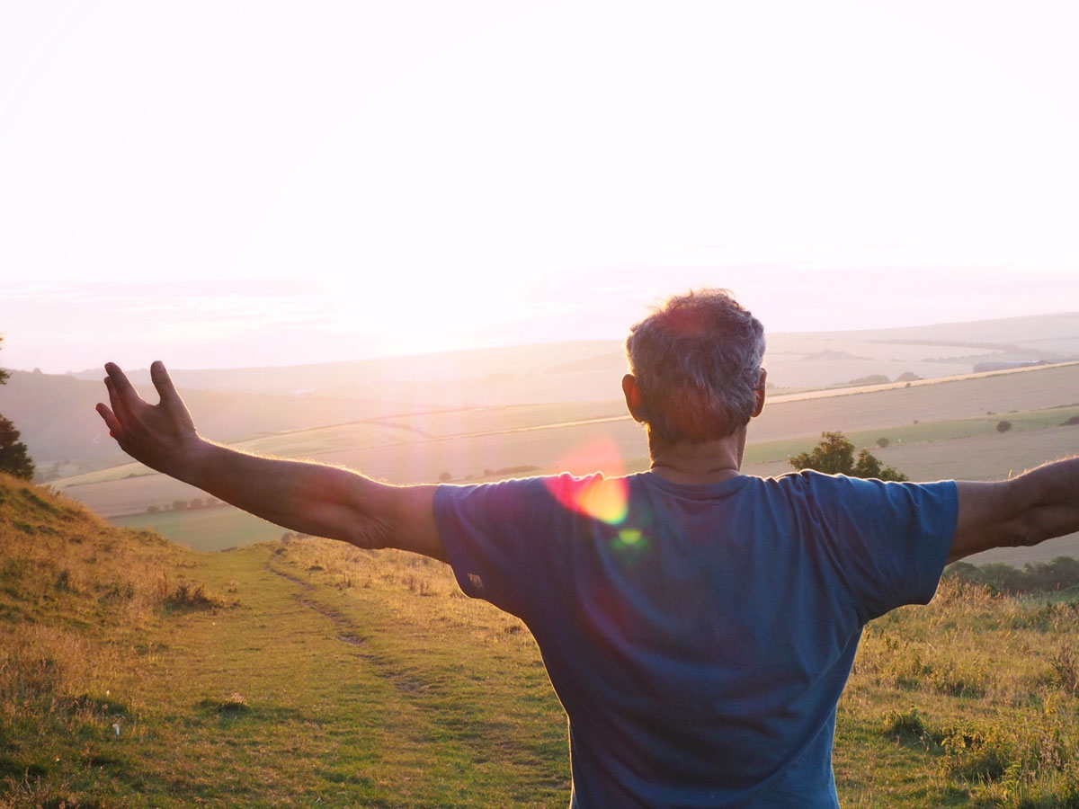 image of man with arms outstretched and open to the sky for a blog article about the inside-out nature of holistic non-12 step recovery.