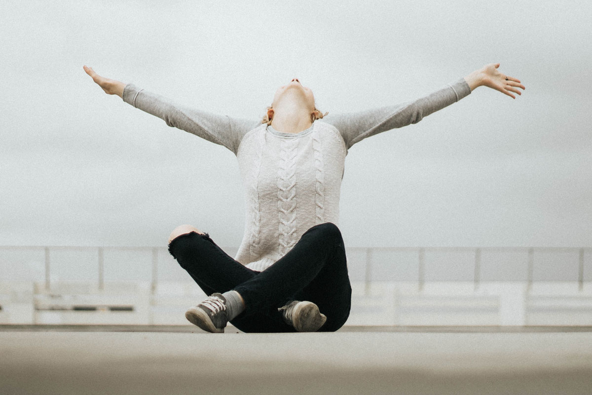 image of woman with her arms outstretched in an expression of joy and happiness on a beach boardwalk for a blog article entitled "The benefits of drug and alcohol rehabilitation at Gulf Breeze Recovery that you may have never thought of but will end up loving!"