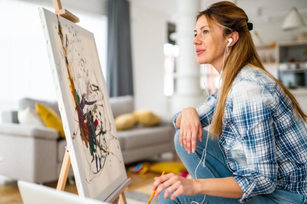 a woman is proud of her work a painting in an art therapy program for substance abuse treatment and recovery