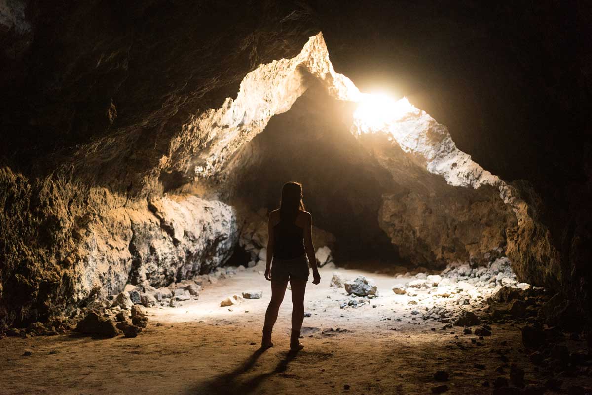 image of a man standing in a cave looking out at the light coming through representing the breakthrough from denial for Gulf Breeze Recovery website