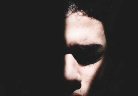 image of man's face partially hidden in darkness for Gulf Breeze Recovery's non-12 step holistic alcohol and drug rehab