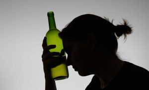 woman with bottle of alcohol half empty for Gulf Breeze Recovery non-12 step holistic alcohol and drug rehab