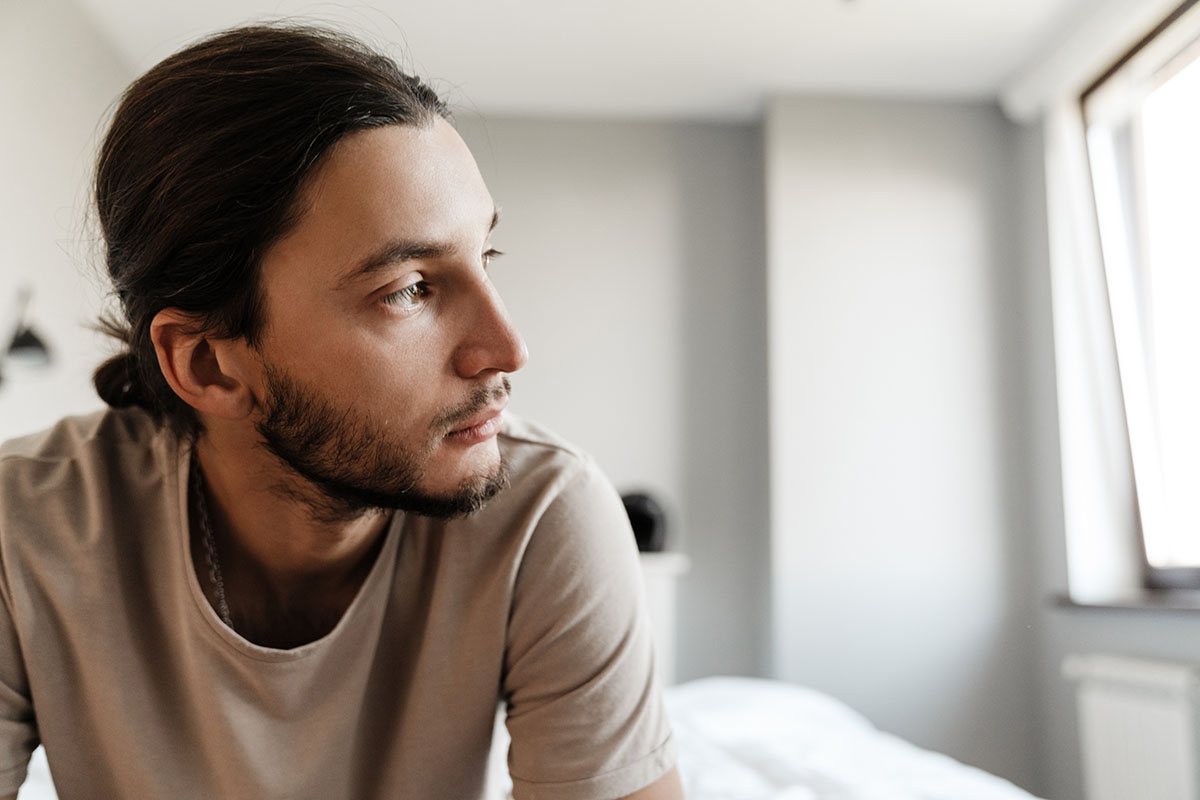 Man sitting alone in room thinking about depression and substance abuse