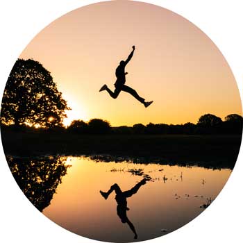 image of man jumping over a lake in a spirit of elation for a blog article entitled "no problems, just situations" for Gulf Breeze Recovery non 12 step holistic drug rehab