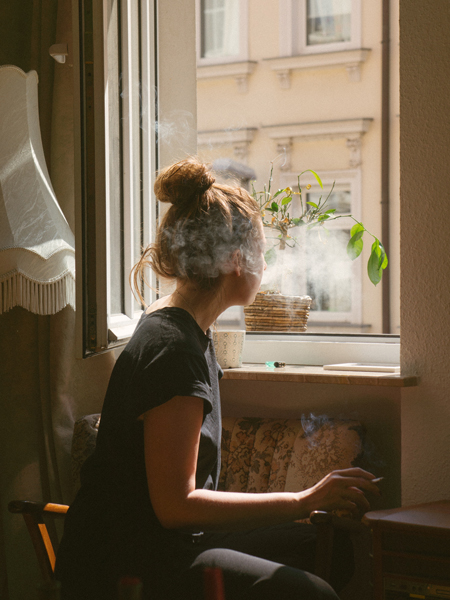 image of woman looking out window obsessively wasting time for a blog article entitled "What I Learned about Cravings at Gulf Breeze Recovery by a Gulf Breeze Recovery graduate" for Gulf Breeze Recovery non-12 step holistic drug and alcohol treatment facility