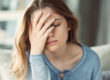 Woman with hand on head, asking herself, "What is alcohol addiction?"