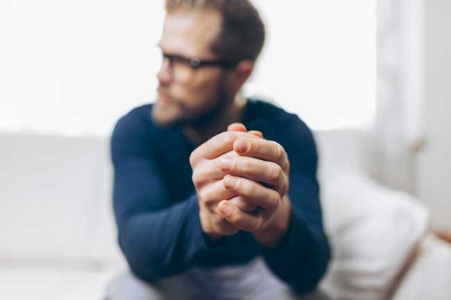 image of man in crisis holding wedding ring. Families often struggle to get a loved one into treatment for an alcohol or drug addiction. Gulf Breeze Recovery non-12 step holistic drug and alcohol rehab