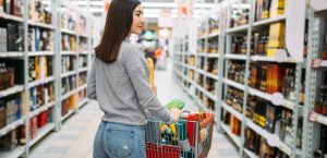 Woman in liquor aisle for Gulf Breeze Recovery's non-12 step rehab in florida blog article entitled "The 3 "A's" of Reducing Alcohol Abuse—And Why American’s Won't Implement Them"