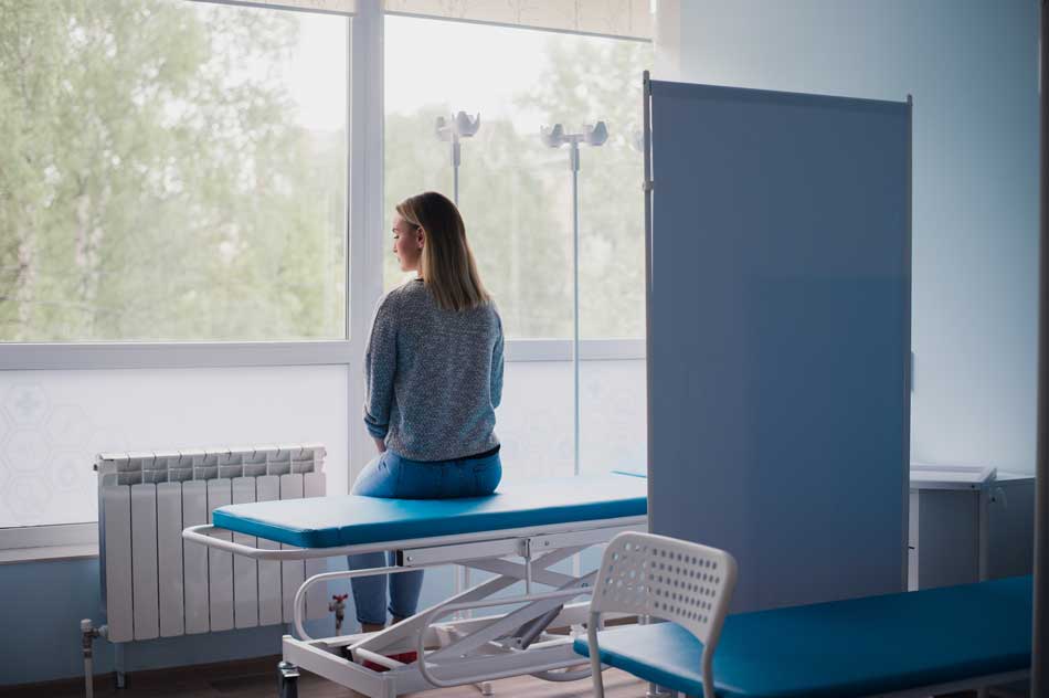 image of pregnant woman sitting on hospital gurney for article about the legal ramifications of using substances while pregnant for Gulf Breeze Recovery Non-12 step holistic drug and alcohol rehab in Florida