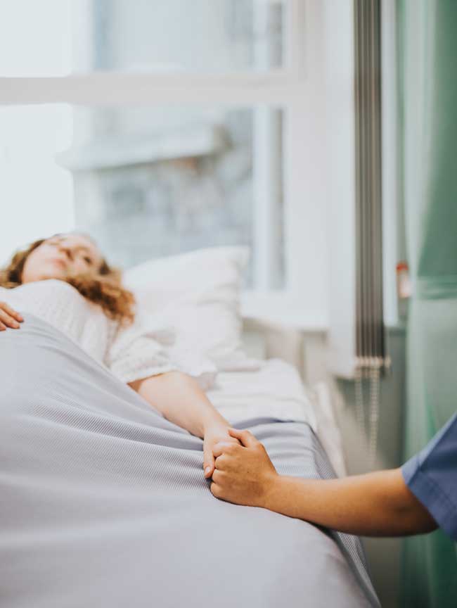 image of woman holding hands with nurse in detoxification wing for Gulf Breeze Recovery's non-12 step holistic alcohol and drug rehab