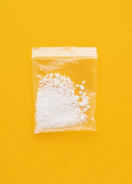 image of baggie of meth on yellow background for Gulf Breeze Recovery non-12 step drug and alcohol treatment center in Florida