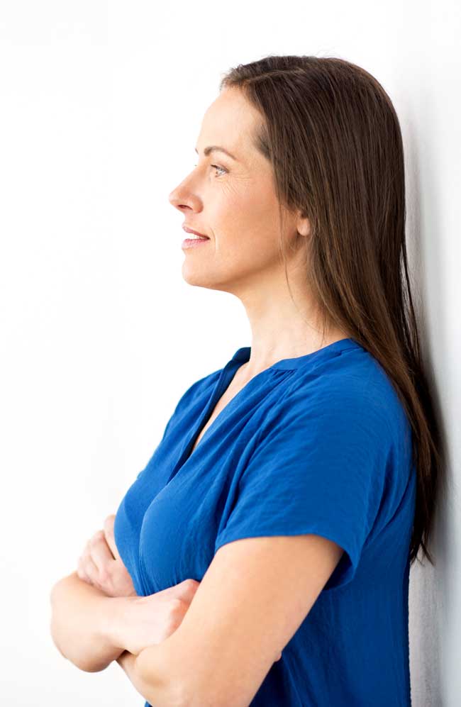 image of woman leaning against wall with arms crossed for Gulf Breeze Recovery non-12 step alcohol treatment in Florida