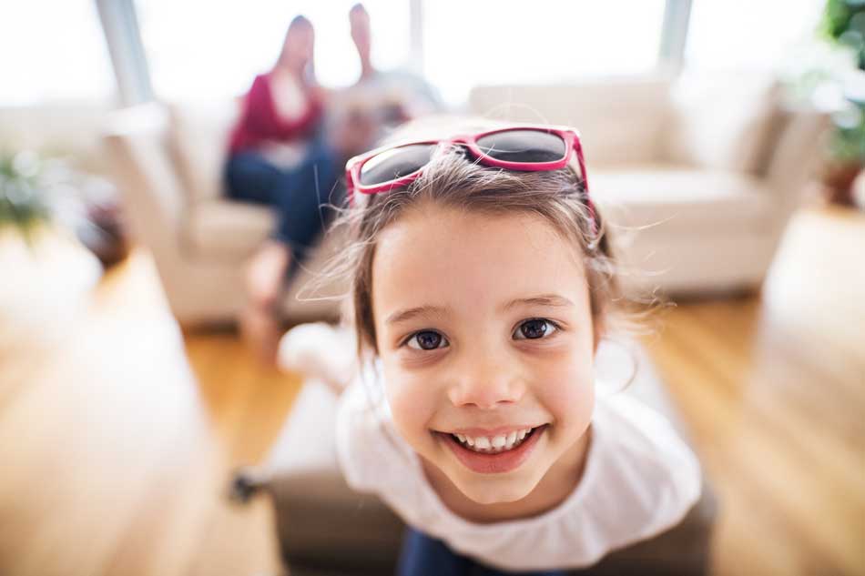 image of a happy child with family in the background around the holidays for article on staying happy through the holidays without relapse for Gulf Breeze Recovery