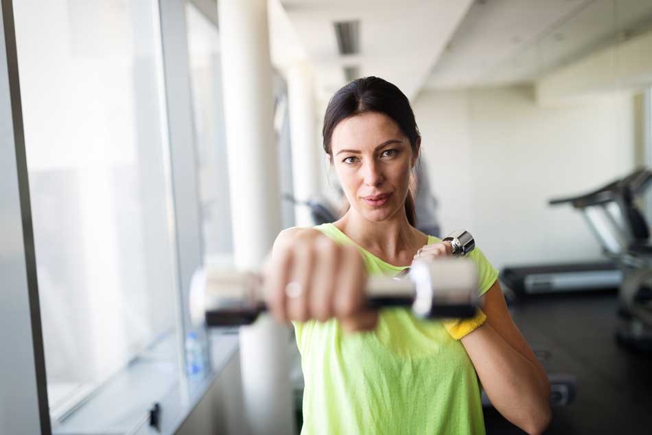 image of woman using light weights for exercise at Gulf Breeze Recovery drug and alcohol treatment center in Florida