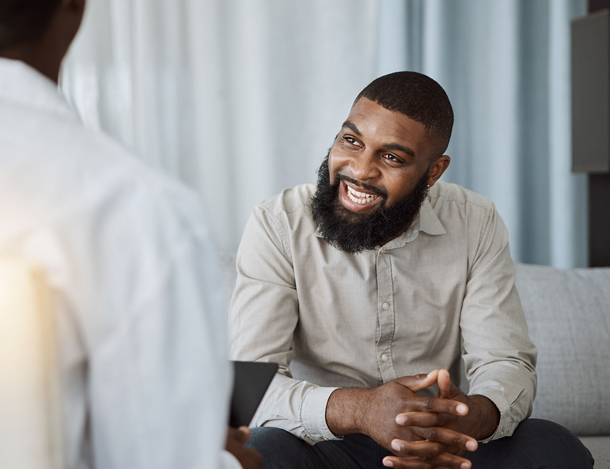 smiling person getting answers to the question what is aftercare while in session with a counselor