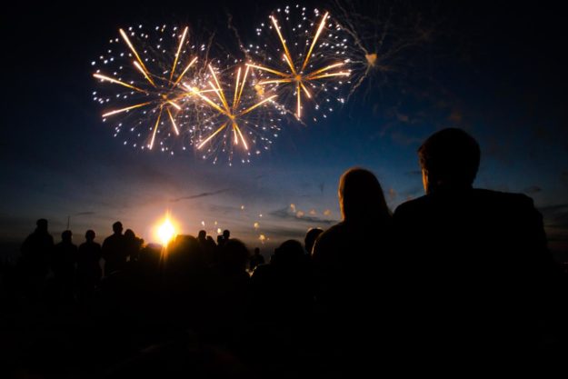 silhouette of couple watching night time fireworks show and following tips to enjoy a sober fourth of july