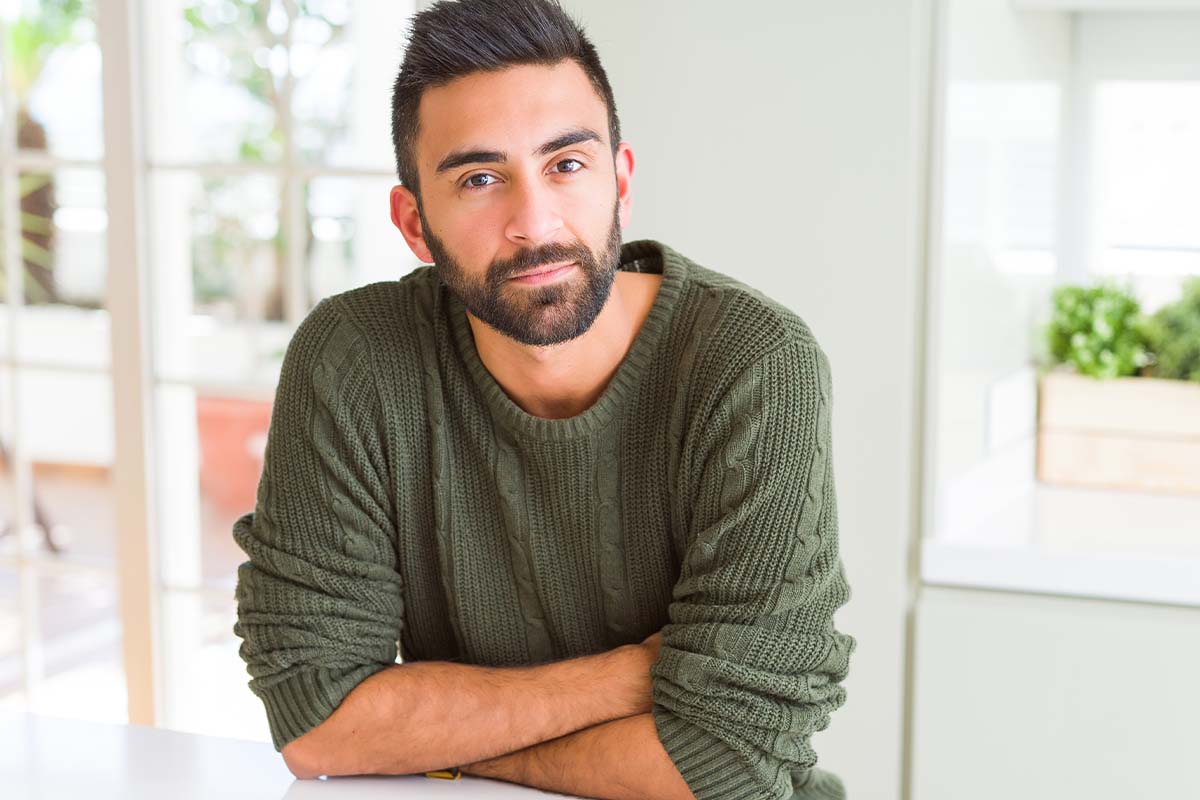 man looks at the camera while pondering how to detox from alcohol