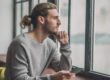 Man looks out a window while pondering the question, "What is drug detox?"