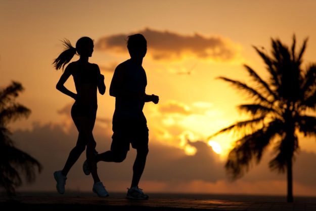 two exercise buddies jog at sunset as part of a holistic exercise therapy program for addiction