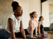 Women doing yoga and contemplating the question: "What is exercise therapy?"