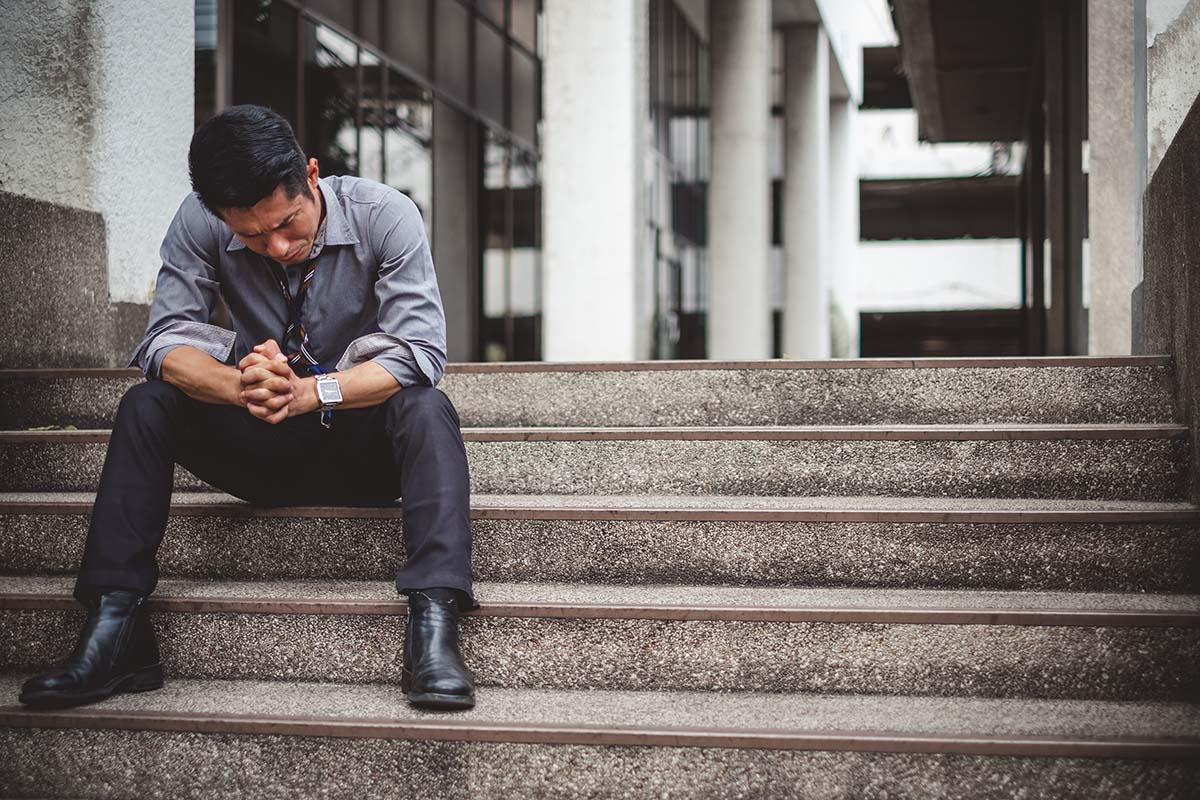 Man sitting on steps and pondering the signs of benzo addiction