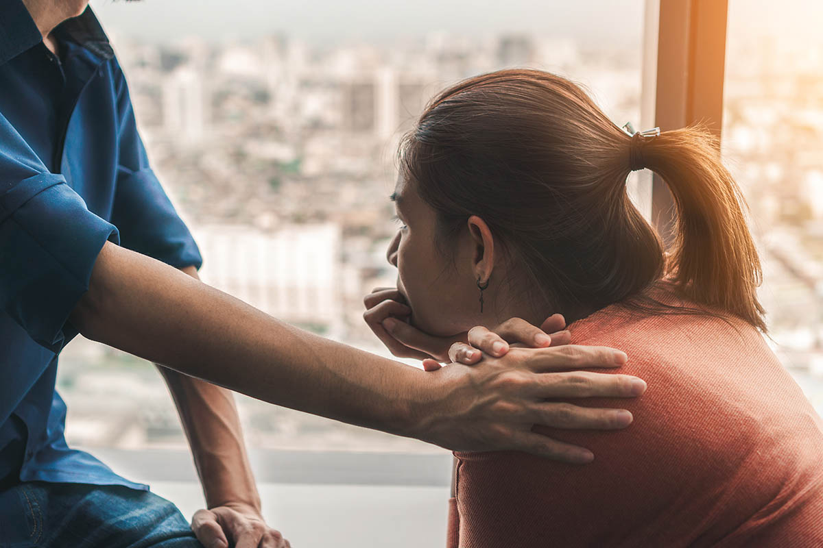 Hand of a person on someone else's shoulders while explaining meth addiction facts