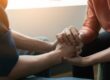 Hands clasped as one person learns how to help someone with opioid addiction
