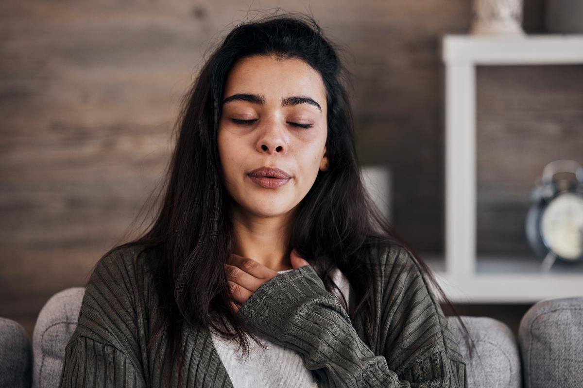Person with eyes closed doing calming breathing exercise to cope with symptoms of PTSD and alcoholism