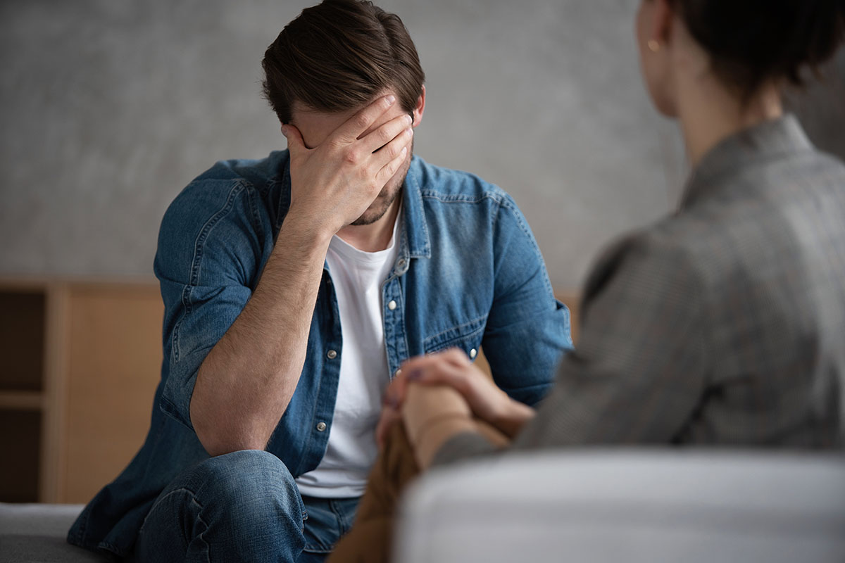 Client in therapy with hand on forehead discussing addiction to the most addictive drugs