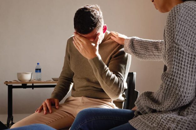 person in therapy being comforted by counselor while reaping anger management benefits