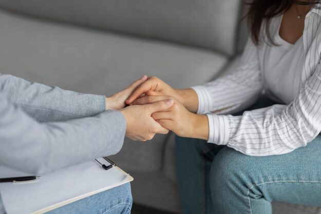 two people joining hands while discussing drug detox benefits