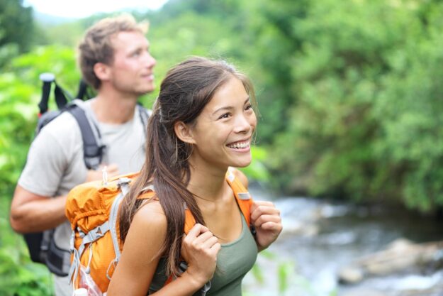 people smiling while hiking in gorgeous natural area after learning about experiential therapy expectations