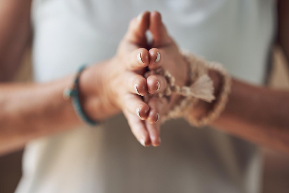 person pressing hands together in meditation after finding holistic rehab in Florida