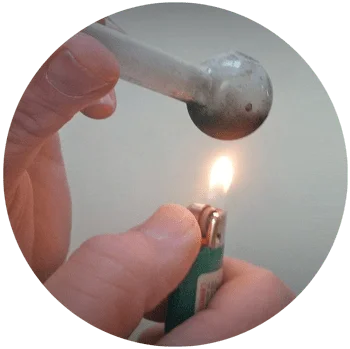 image of a person hitting meth with dirty glass pipe and bic lighter for a blog article entitled "Teenagers Exhibit Most Risk for Methamphetamine Side Effects" for Gulf Breeze Recovery non 12 step holistic drug rehab