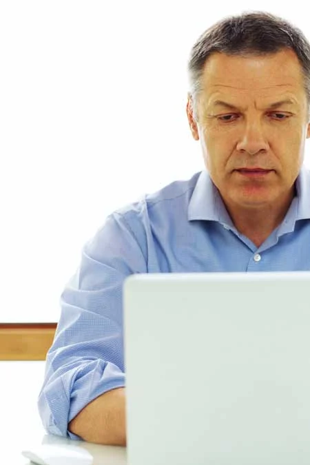 image of man on laptop researching treatment for alcohol addiction for "Why New Year Resolutions Don’t Work on Alcohol Addiction"