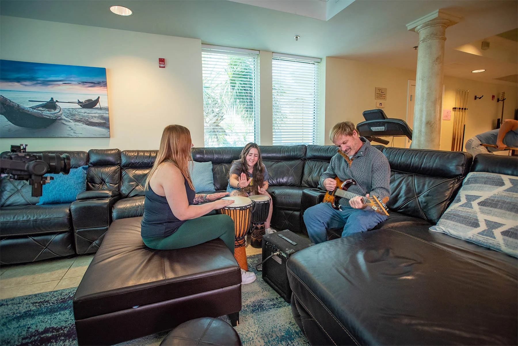 Three people sitting on a couch playing instruments for music therapy