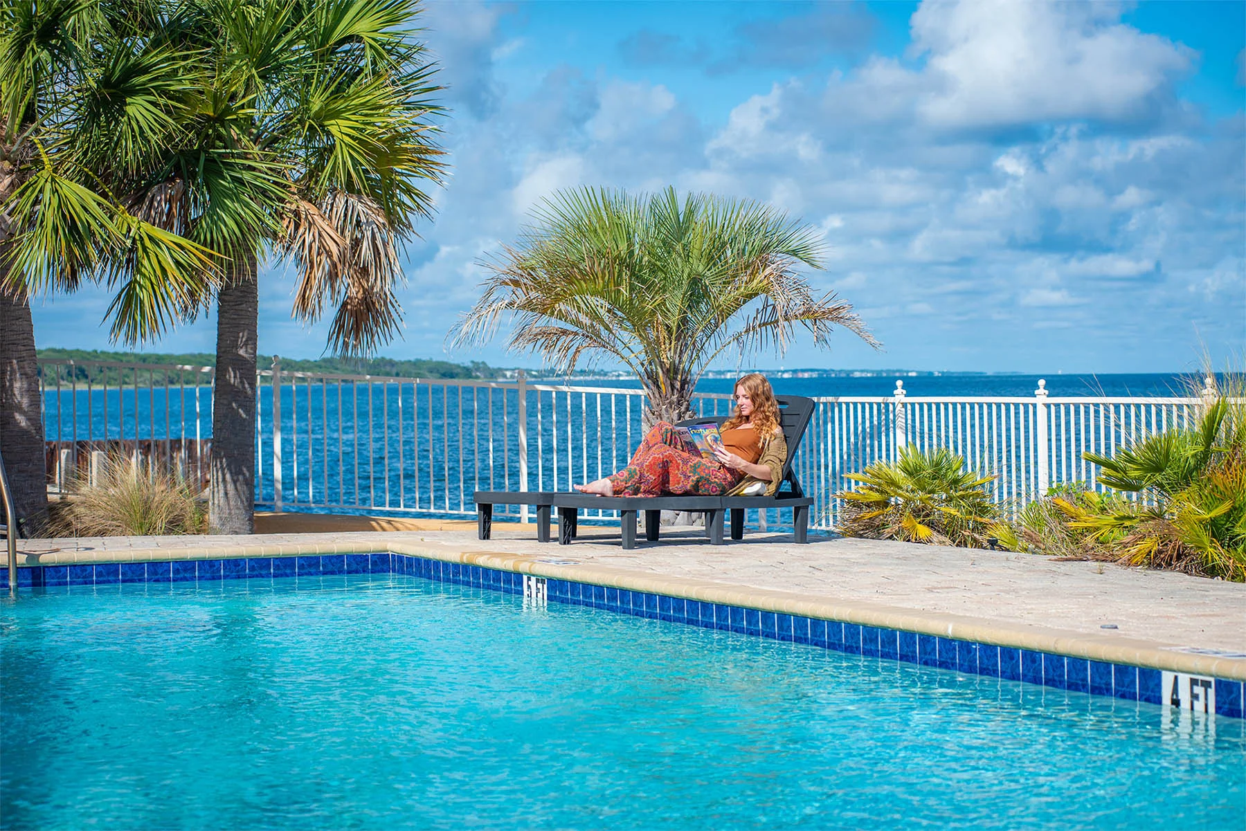 Two people sitting on chairs poolside