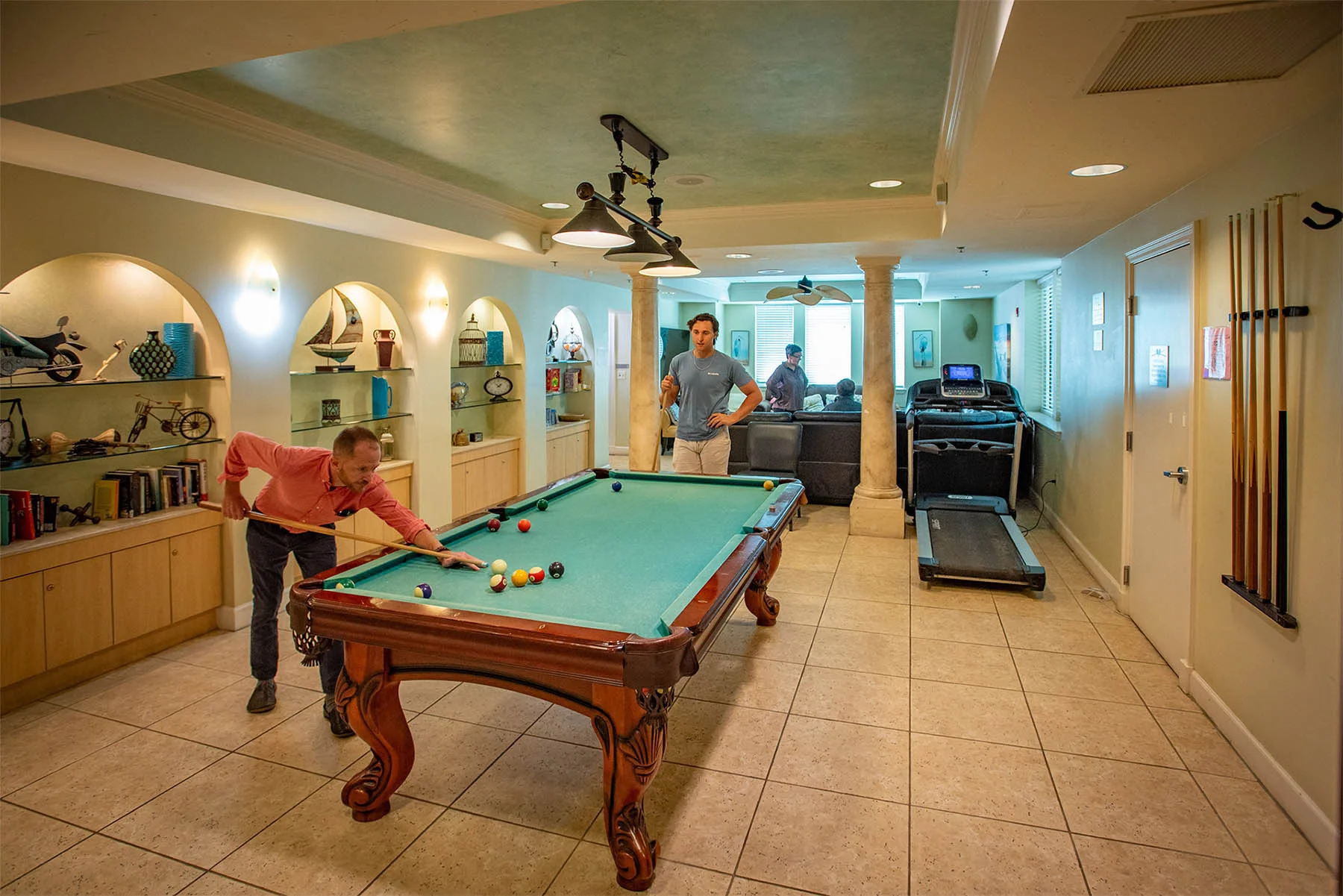 Two men playing pool in well lit room