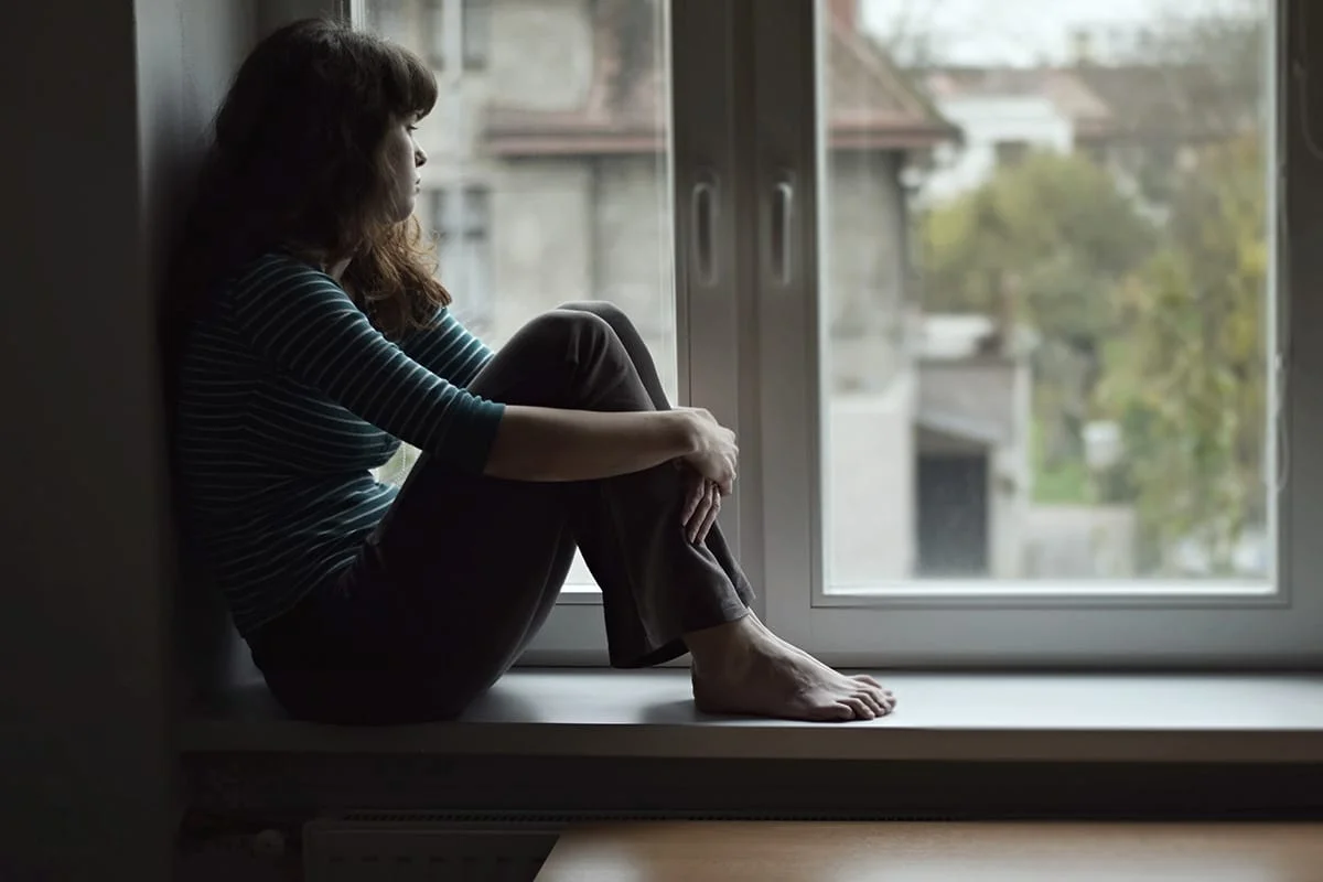 a woman looking out her window suffering from fentanyl side effects