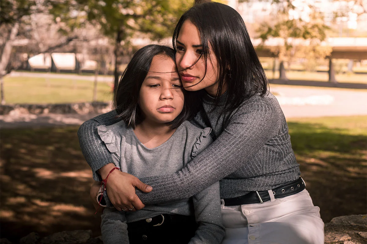 A woman holding a child and wondering