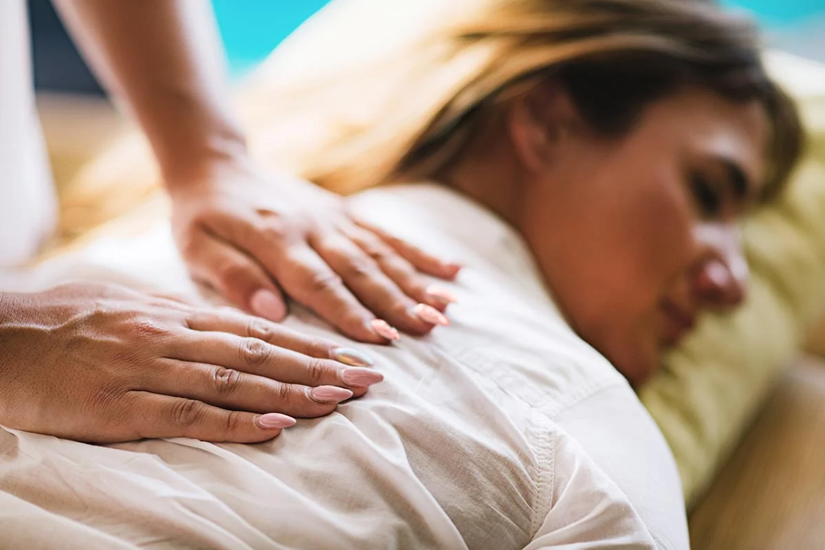 Woman receives a back massage while wondering